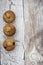 Vertical image of three blueberry muffins on a wooden background