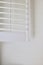 Vertical image of white plantation shutters against plain white wall