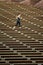 Vertical image woman jogging across seating rows at Red Rocks Amphitheater located in Morrison Colorado