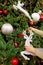 Vertical Image of Woman`s Hands Decorating Glitter Reindeer Shaped Ornament onto the Christmas Tree