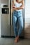 Vertical image of woman standing near the fridge