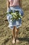 Vertical image.Woman wearing rural apron and holding fresh harvested corn ears