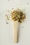 Vertical image.Wooden spoon full of mix of cereals on the white table