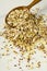 Vertical image of wooden spoon and heap of dry cereal, oat, seeds for healthy eating