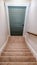 Vertical Indoor stairs of home with carpeted treads that leads down to the basement door