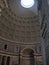 Vertical inside view of a pantheon in Rome with light coming from the dome