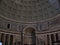 Vertical inside view of a pantheon in Rome with light coming from the dome