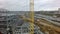 A vertical inspection of a construction crane against the building frame and a busy highway