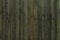 Vertical lacquered bamboo wood planks with striped pattern background. Surface of greenish black colored bamboo boards texture.