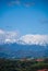 Vertical landscape of valley with houses and with the Picos de Europa snowed in the background