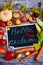 Vertical layout of autumn harvest of vegetables and fruits on a wooden background with text Hello Autumn. Vegan organic