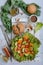 Vertical layout on a light wooden background. Delicious tomatoes, cucumbers, lettuce, spices and round bran bread. Healthy and