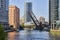 Vertical lift bridge raised over two boats on Chicago canal with skyscrapers on sunny summer day