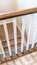 Vertical Looking down on U shaped indoor staircase with white baluster and brown handrail