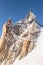 Vertical low-angle closeup of Aiguille du Midi mountain peak with clear sky background