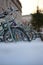 Vertical low-angle of a line of bicycles outdoors buildings and sunlit sky blurred background