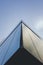 Vertical low angle shot of a corner of a modern building under the blue sky