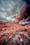 Vertical low angle shot of a desert surrounded by cliffs under the beautiful sky shot in infrared