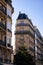 Vertical low-angle shot of modernized medieval buildings' exteriors before the blue skyline in Paris