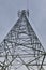 Vertical low angle shot of a power line tower  on a gloomy sky background