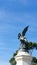 Vertical low-angle shot of a statue of a fallen angel in the Retiro Park, Madrid, Spain