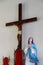 Vertical low angle shot of the statue of Mother Mary and the Christ on the Cross on a white wall