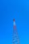 Vertical low angle shot of a tall radio tower under a clear blue beautiful sky