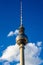 Vertical low angle shot of the top of the famous Fernsehturm tower in Berlin against the blue sky