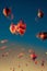 Vertical low angle shot of trippy vibrant warped hot air balloons in the blue sky