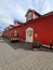 Vertical low-angle of a wooden red house cloudy sky background