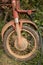 Vertical Medium shot of muddy front fork, wheel, and frame of light motorcycle