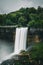 Vertical mesmerizing view of a gracefully falling waterfall on cliffs in the forests