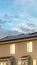 Vertical Multi storey home with solar panel on the roof against cloudy sky