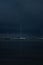 Vertical night view of a sea with boats in it