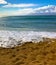 Vertical Ocean Tide on Sandy Beach with Bright Cloudy Sky