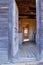 Vertical of an open wooden door with the view of an abandoned house.