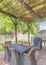 Vertical Outdoor patio with covered barbecue grill under a pergola roof with vines