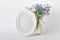 Vertical oval frame with blue wild forest flowers
