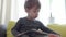 Vertical pan close up authentic sick little preschool excited child boy 2-3 years examines and reads book with open