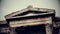 Vertical pan shot of ancient Greek architecture landmark, black and white film
