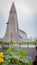 Vertical panorama of hallgrimskirkja, in soft focus with closeup of flowers and leaves with water droplets in front of it