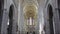 Vertical panorama inside view of catholic cathedral with columns, statues of pope