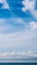 VERTICAL PANORAMA real photo natural cloudscape wallpaper. Beautiful white fluffy cumulus clouds summer blue sky calm