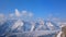 Vertical panorama of snowy mountains, bright blue sky. Winter vacation, tourism