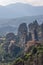 Vertical panoramic photo of the Monasteries of St. Nicholas Anapausas far behind and Rousanou in front, Meteora religious complex