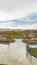 Vertical Park with view of vast cloudy sky over snow peaked mountain and homes