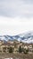 Vertical Paved road curving through snowy hill with multi storey homes in the distance