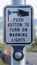 Vertical Pedestrian push button station at a crosswalk against blurred road and mountain