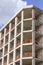 Vertical perspective shot of construction of a new reinforced concrete and metal beams linked building with open blue sky