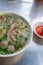 Vertical photo of bowl of Vietnamese Pho beef noodles soup